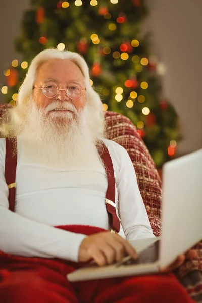 Feliz Papai Noel digitando no laptop — Fotografia de Stock