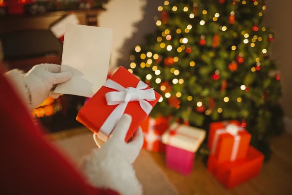 Santa Claus sosteniendo papel y regalo — Foto de Stock