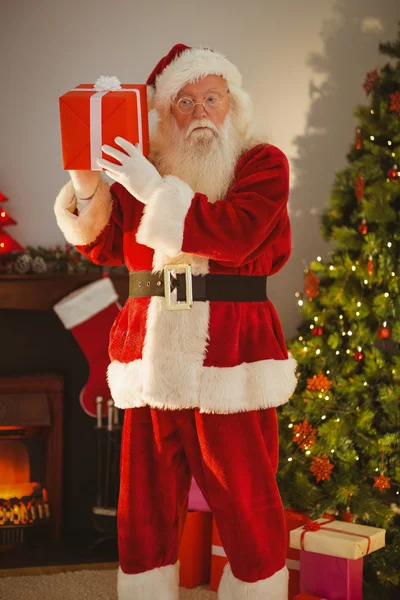Father christmas holding gift at christmas eve — Stock Photo, Image