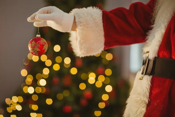 Hand of santa holding a bauble — Stock Photo, Image