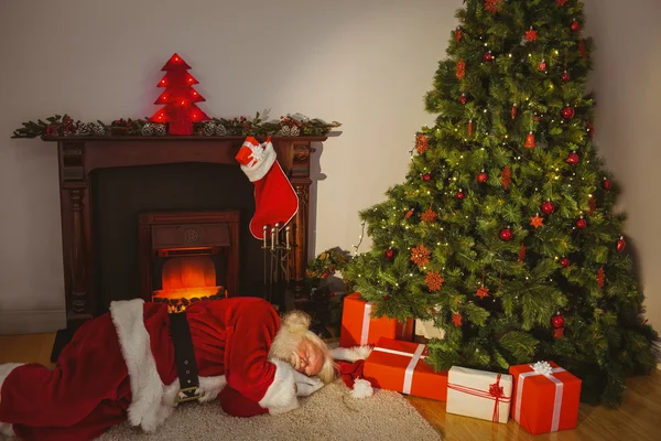 Weihnachtsmann schläft auf dem Teppich — Stockfoto