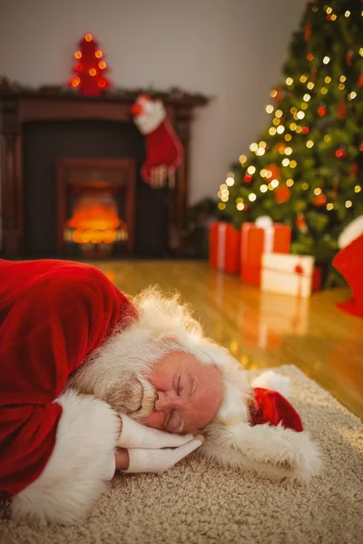 Weihnachtsmann macht Nickerchen auf dem Teppich — Stockfoto