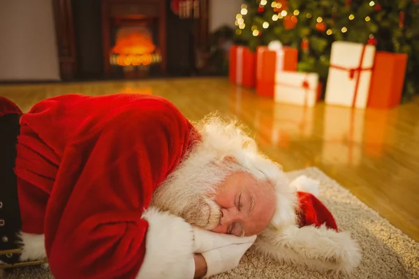 Отец Рождества спит на ковре — стоковое фото