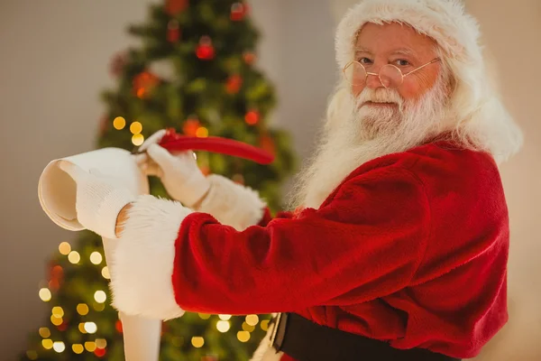 Lächelnder Weihnachtsmann schreibt Liste — Stockfoto