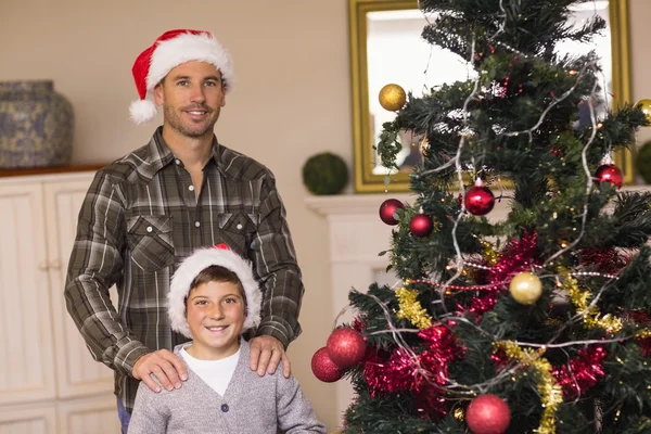 Pappa och son poserar nära julgranen — Stockfoto