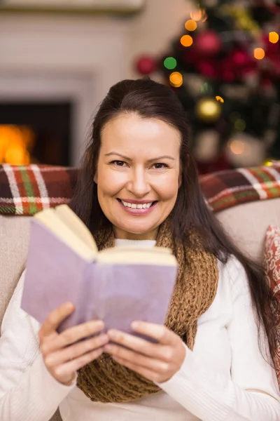 Lachende brunette lezen op de Bank — Stockfoto