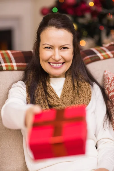 Hezká brunetka žena nabízí vánoční dárek — Stock fotografie