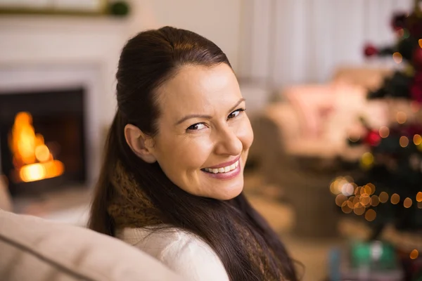 Portrait of a brunette sitting on couch at christmas — Stock Photo, Image