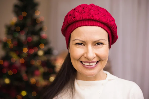 Portræt af en smilende brunette i rød hat - Stock-foto