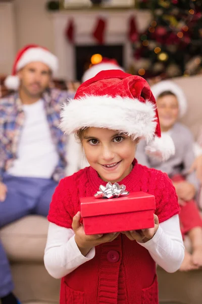 Lächelnde Tochter hält Geschenk vor ihrer Familie — Stockfoto