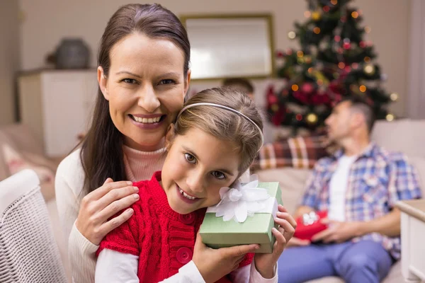 Filha segurando um presente com sua mãe — Fotografia de Stock