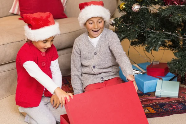 Förvånad över bror och syster öppnar en gåva — Stockfoto