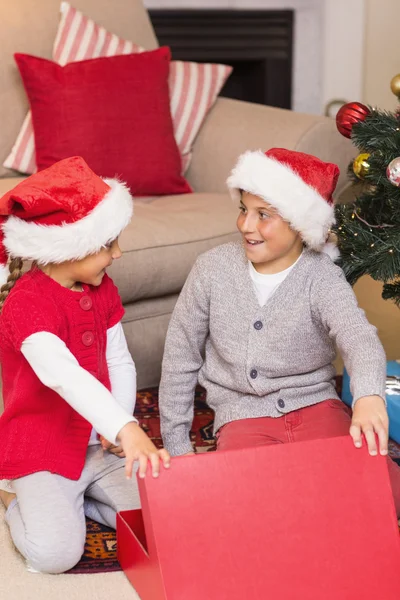 Sorprendidos hermano y hermana abriendo un regalo —  Fotos de Stock