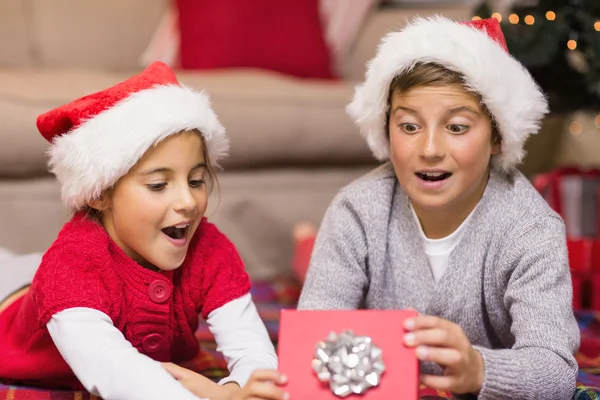 Geschockte Geschwister beim Öffnen eines Geschenks — Stockfoto