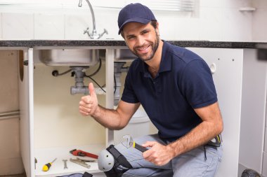 Plumber fixing under the sink clipart