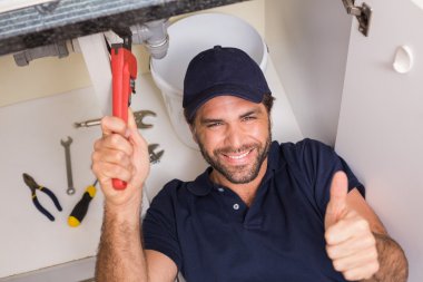 Plumber fixing under the sink clipart