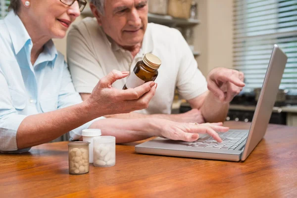 Para starszy patrząc online leków — Zdjęcie stockowe