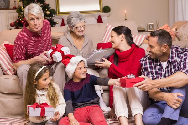 Familia multi generación intercambiando regalos en el sofá — Foto de Stock