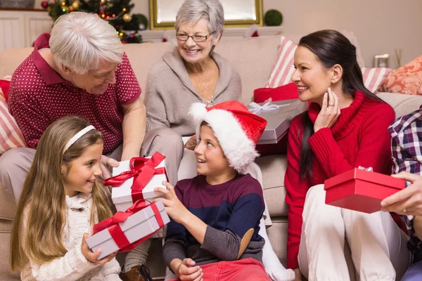 Familia multigeneracional intercambiando regalos en sofá —  Fotos de Stock