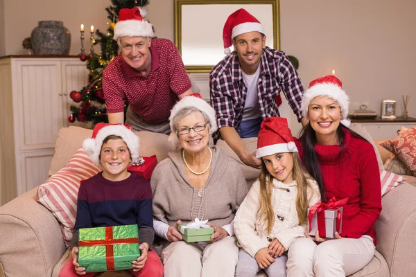 Portrait d'une famille élargie heureuse en chapeau de Père Noël tenant des cadeaux — Photo