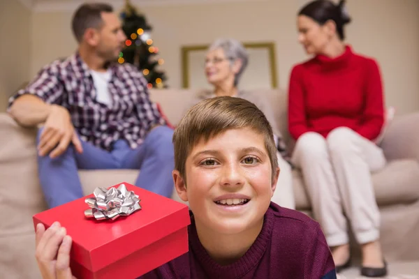Usměvavý syn s darem před jeho rodina — Stock fotografie