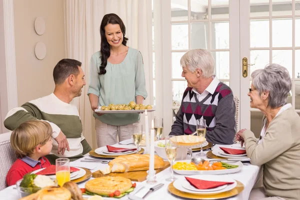 Mujer sirviendo la cena de Navidad a su familia —  Fotos de Stock