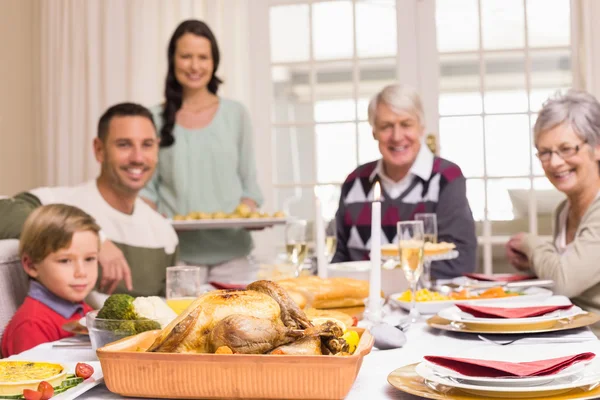 Mulher segurando jantar de Natal com a família na mesa de jantar — Fotografia de Stock