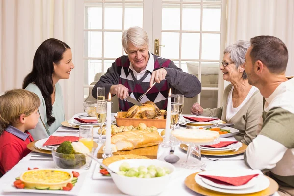 Grandfather carving chicken during christmas dinner — Stock Photo, Image