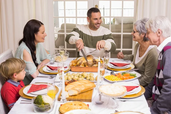 Man carving chicken during christmas dinner — Stock Photo, Image
