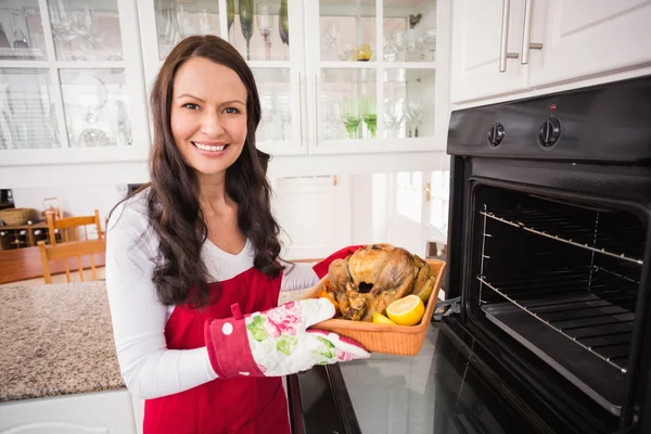 Pretty brunette taking out the roast turkey — Stock Photo, Image