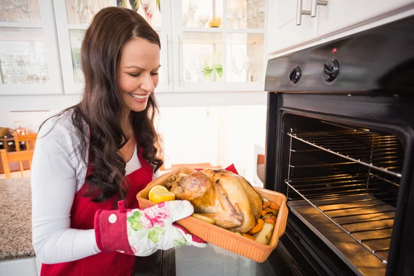Smiling woman taking out her roast turkey — Stock Photo, Image