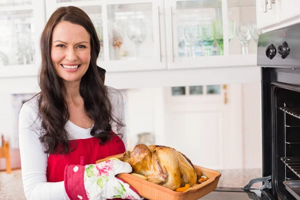 Mujer sonriente sosteniendo pavo asado — Foto de Stock