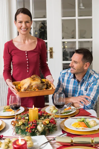 Couple smiling while woman holding roast turkey — Stock Photo, Image