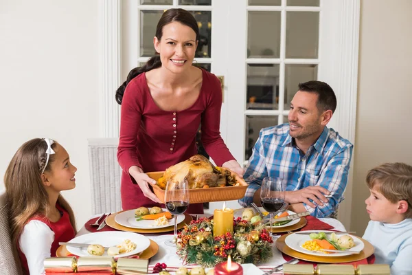 Lachende vrouw serveren gebraden Turkije naar haar familie — Stockfoto