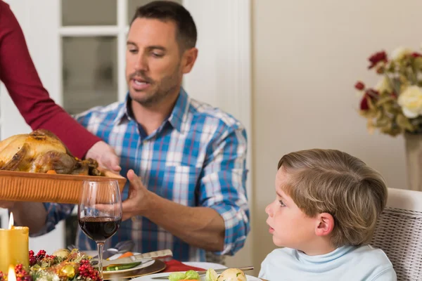 Woman passing the roast turkey to her husband — Stock Photo, Image