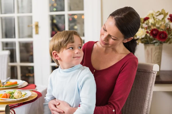 Sonriente madre con su hijo sentado en el regazo — Foto de Stock