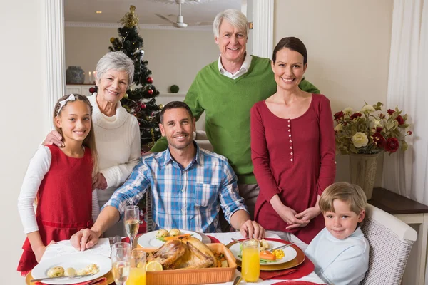 Smiling extended family looking at camera at christmas time — Stock Photo, Image