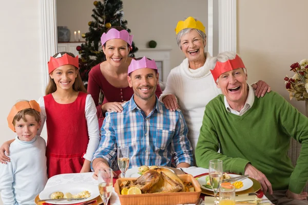 Gelukkig familie in feest hoed aan diner tafel — Stockfoto