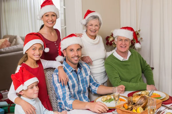 Gelukkig familie in Kerstman hoed camera kijken — Stockfoto