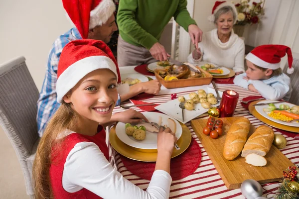 Portrét roztomilé děvče v santa hat během Štědrovečerní večeře — Stock fotografie