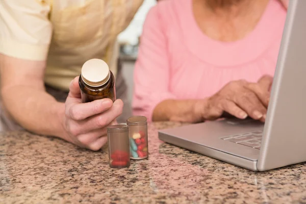 Senior couple looking up medication online — Stock Photo, Image