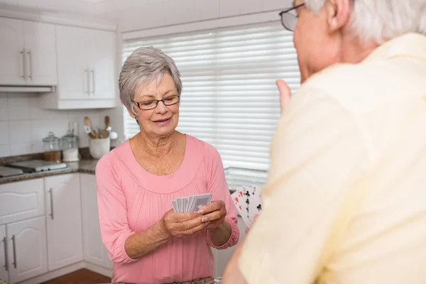 Senior koppel speelkaarten bij de balie — Stockfoto