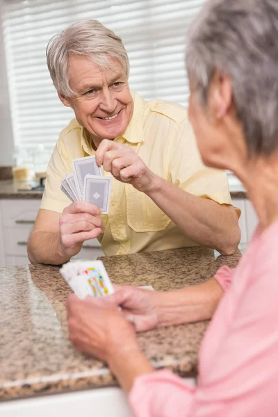 Couple senior jouant aux cartes au comptoir — Photo