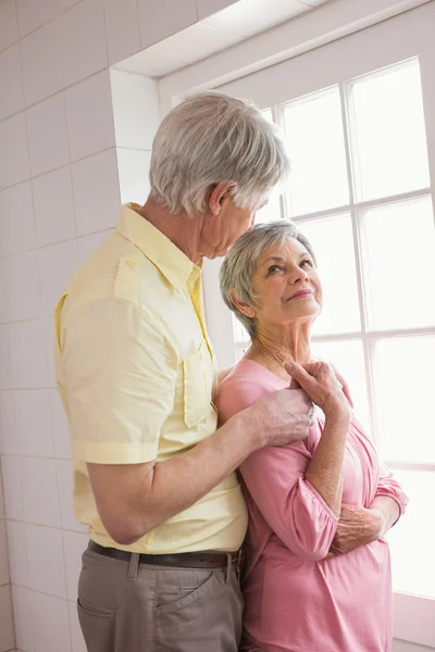 Senior paar kijkt uit hun raam — Stockfoto