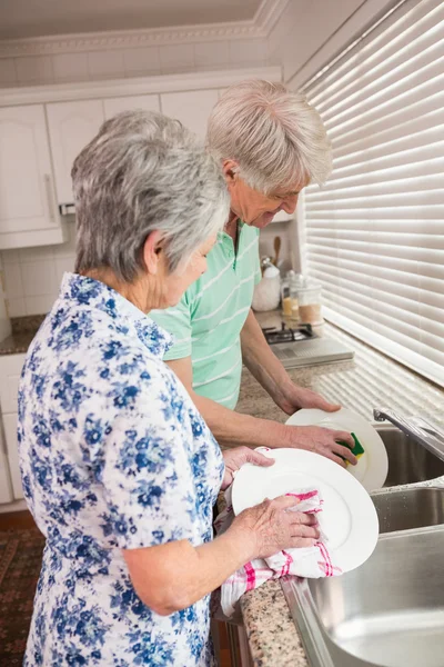 Pareja mayor lavando los platos — Foto de Stock