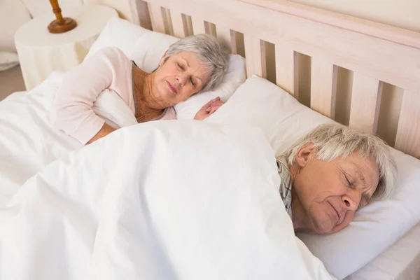 Äldre par sova i sängen — Stockfoto