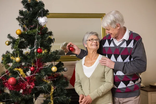 Äldre par dekorera sin julgran — Stockfoto