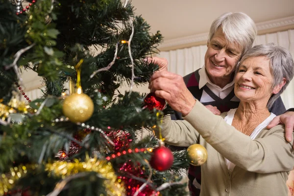 Äldre par dekorera sin julgran — Stockfoto