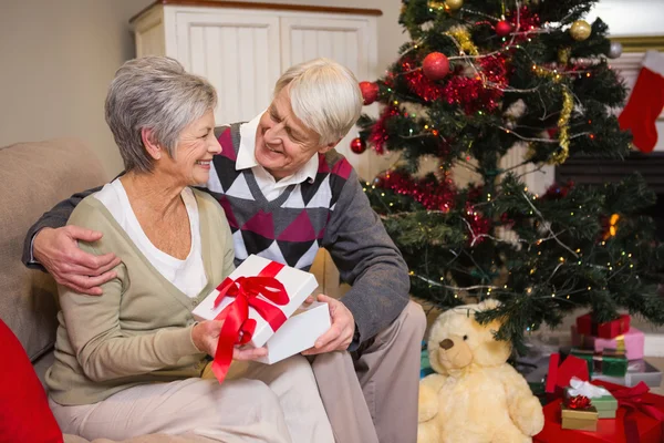 Pareja mayor sentada junto a su árbol de Navidad — Foto de Stock