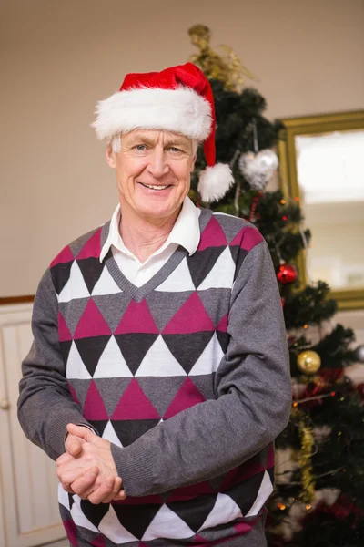 Senior man die lacht naast de kerstboom — Stockfoto